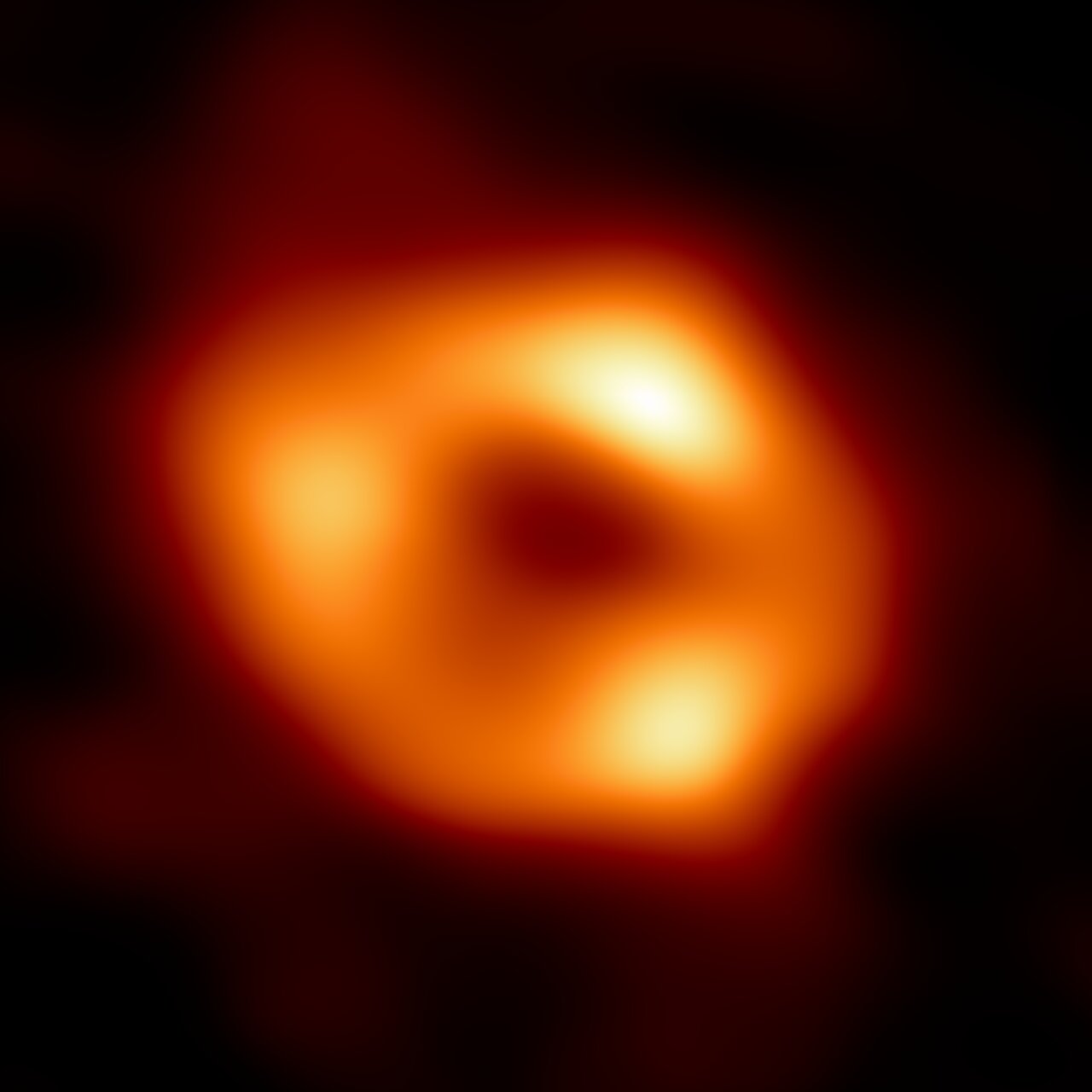This is the first image of Sgr A*, the supermassive black hole at the centre of our galaxy. It’s the first direct visual evidence of the presence of this black hole. It was captured by the Event Horizon Telescope (EHT), an array which linked together eight existing radio observatories across the planet to form a single “Earth-sized” virtual telescope. The telescope is named after the event horizon, the boundary of the black hole beyond which no light can escape. Although we cannot see the event horizon itself, because it cannot emit light, glowing gas orbiting around the black hole reveals a telltale signature: a dark central region (called a shadow) surrounded by a bright ring-like structure. The new view captures light bent by the powerful gravity of the black hole, which is four million times more massive than our Sun. The image of the Sgr A* black hole is an average of the different images the EHT Collaboration has extracted from its 2017 observations. In addition to other facilities, the EHT network of radio observatories that made this image possible includes the Atacama Large Millimeter/submillimeter Array (ALMA) and the Atacama Pathfinder EXperiment (APEX) in the Atacama Desert in Chile, co-owned and co-operated by ESO is a partner on behalf of its member states in Europe.