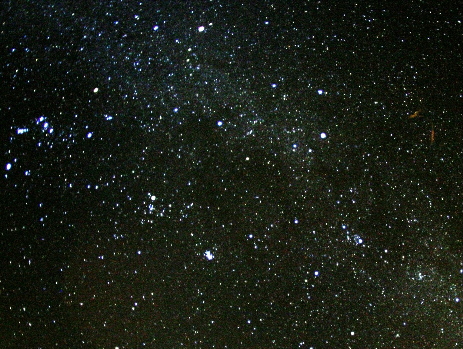 The brightest meteor, a fireball, leaves a persistent smoky trail drifting in high-altitude winds, which is seen on the right side of the image.
